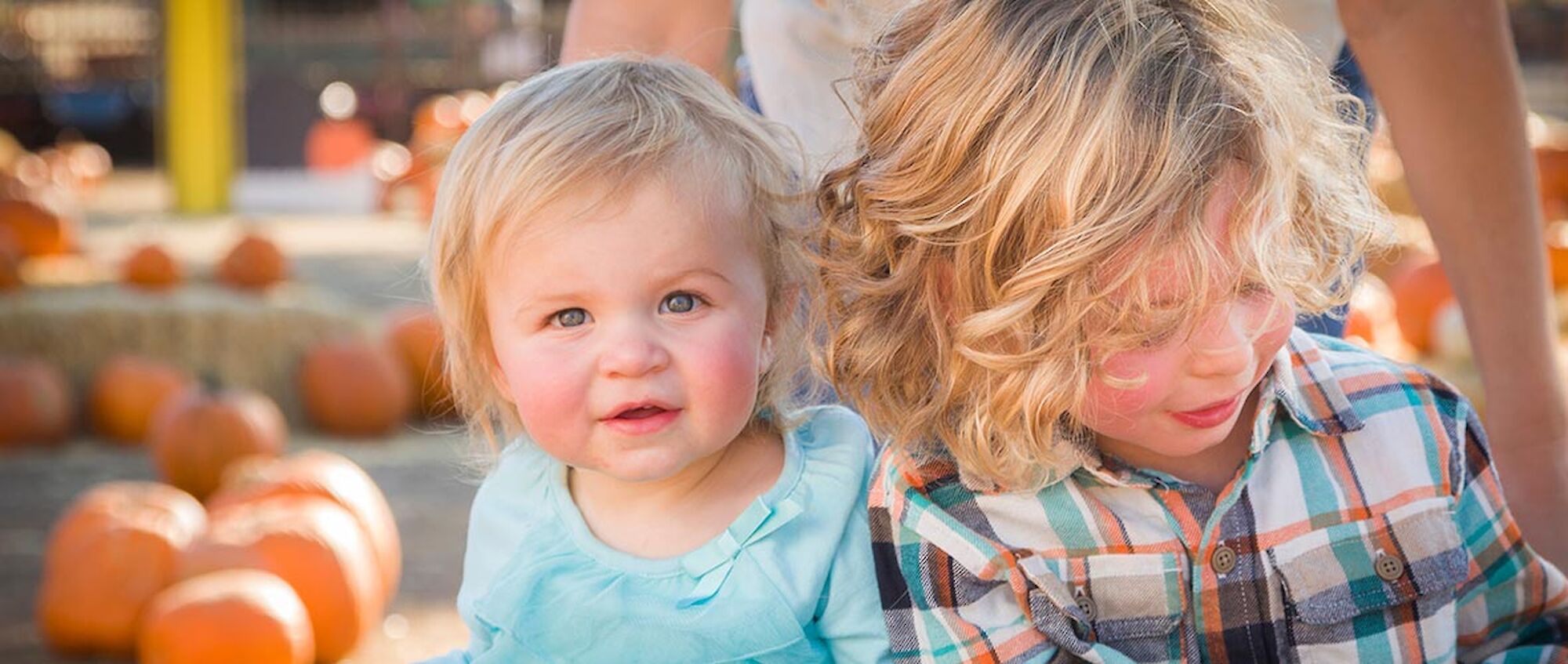 photo of two young children in a display of pumpkins