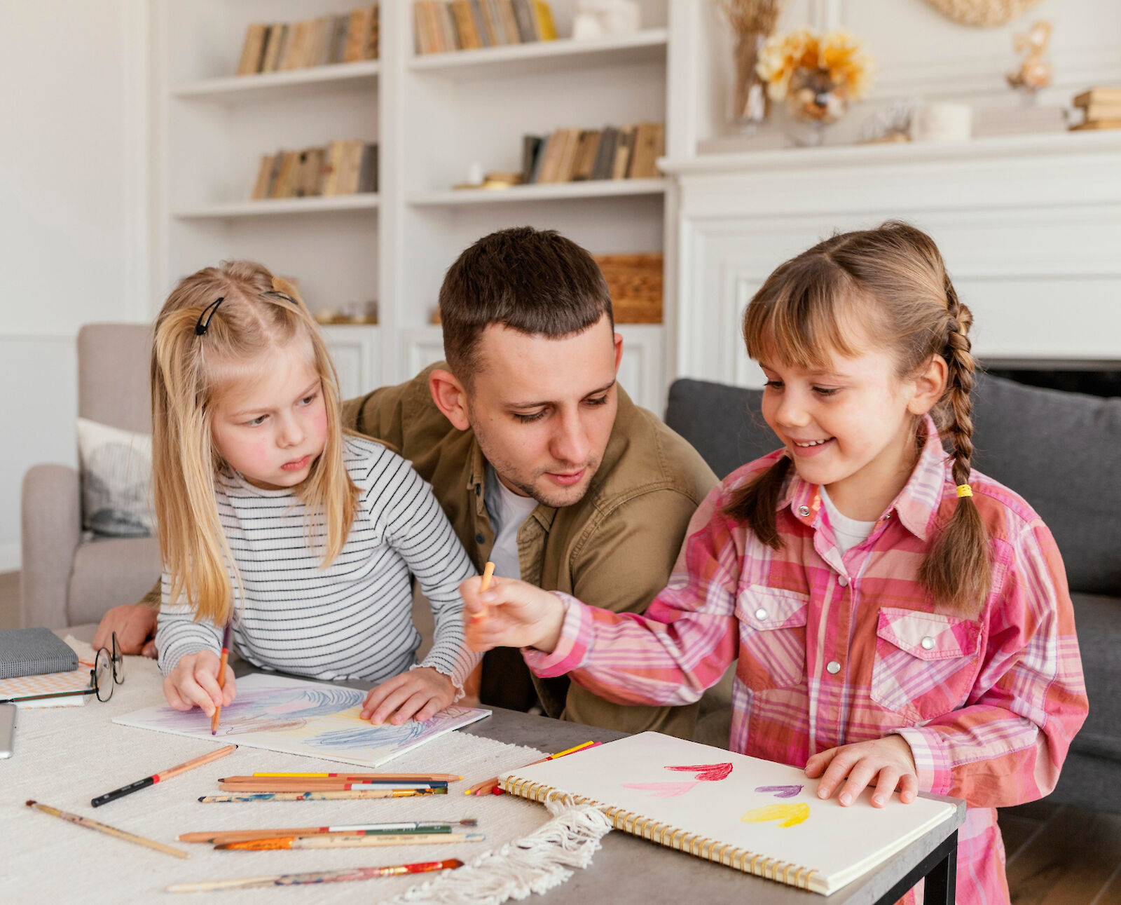 father with young daughters in an art project